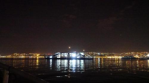 Izmir car ferry underway after disk. Approaching Uckuyular, Izmir ferry boat stop. The background is Izmir by night.