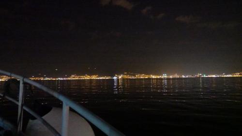 Izmir car ferry underway after disk. Approaching Uckuyular, Izmir ferry boat stop. The background is Izmir by night.